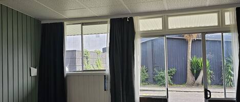 Una habitación con cama, ventana con cortinas y vistas al exterior.