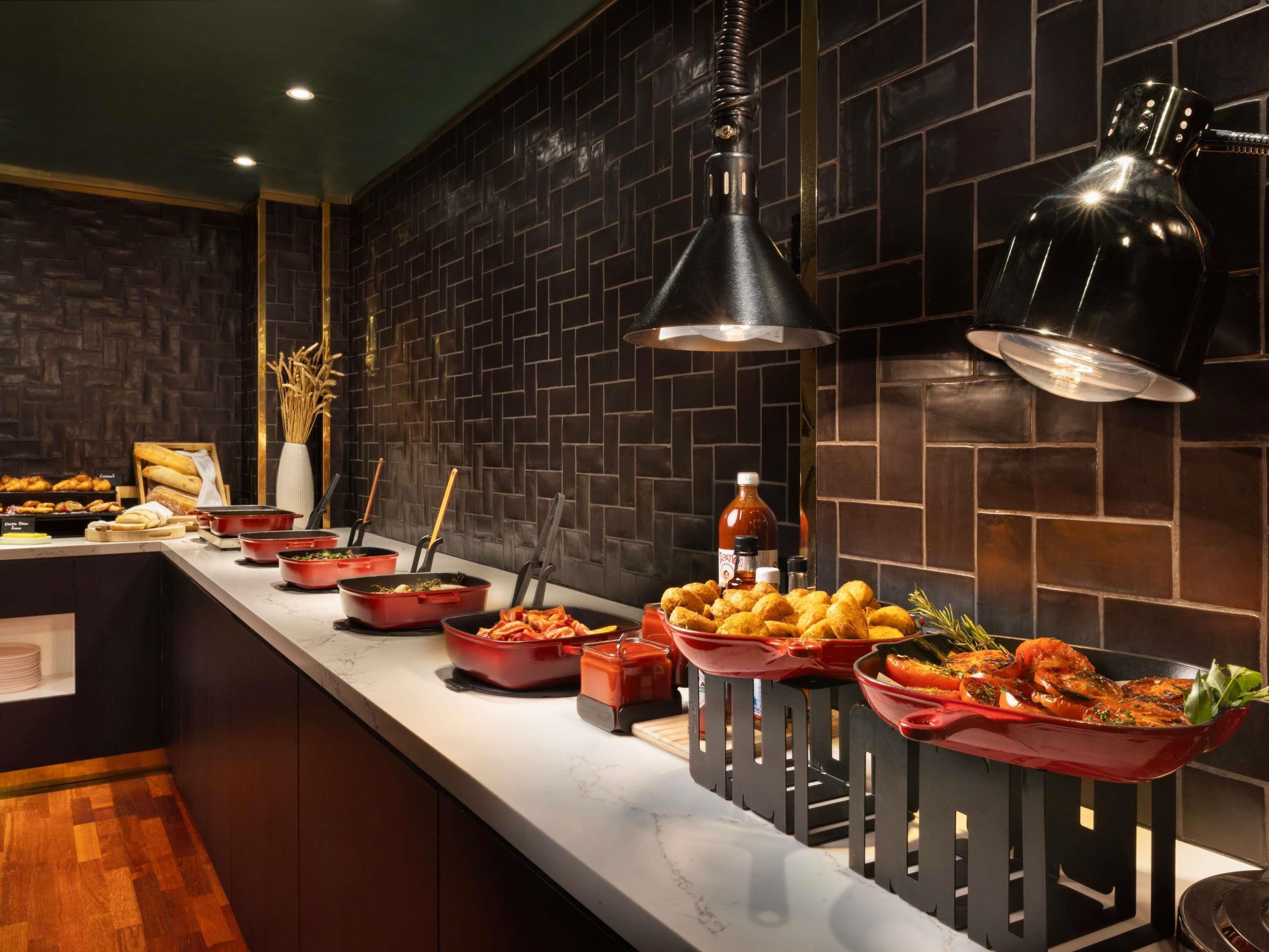 A buffet setup with various food items and serving utensils.