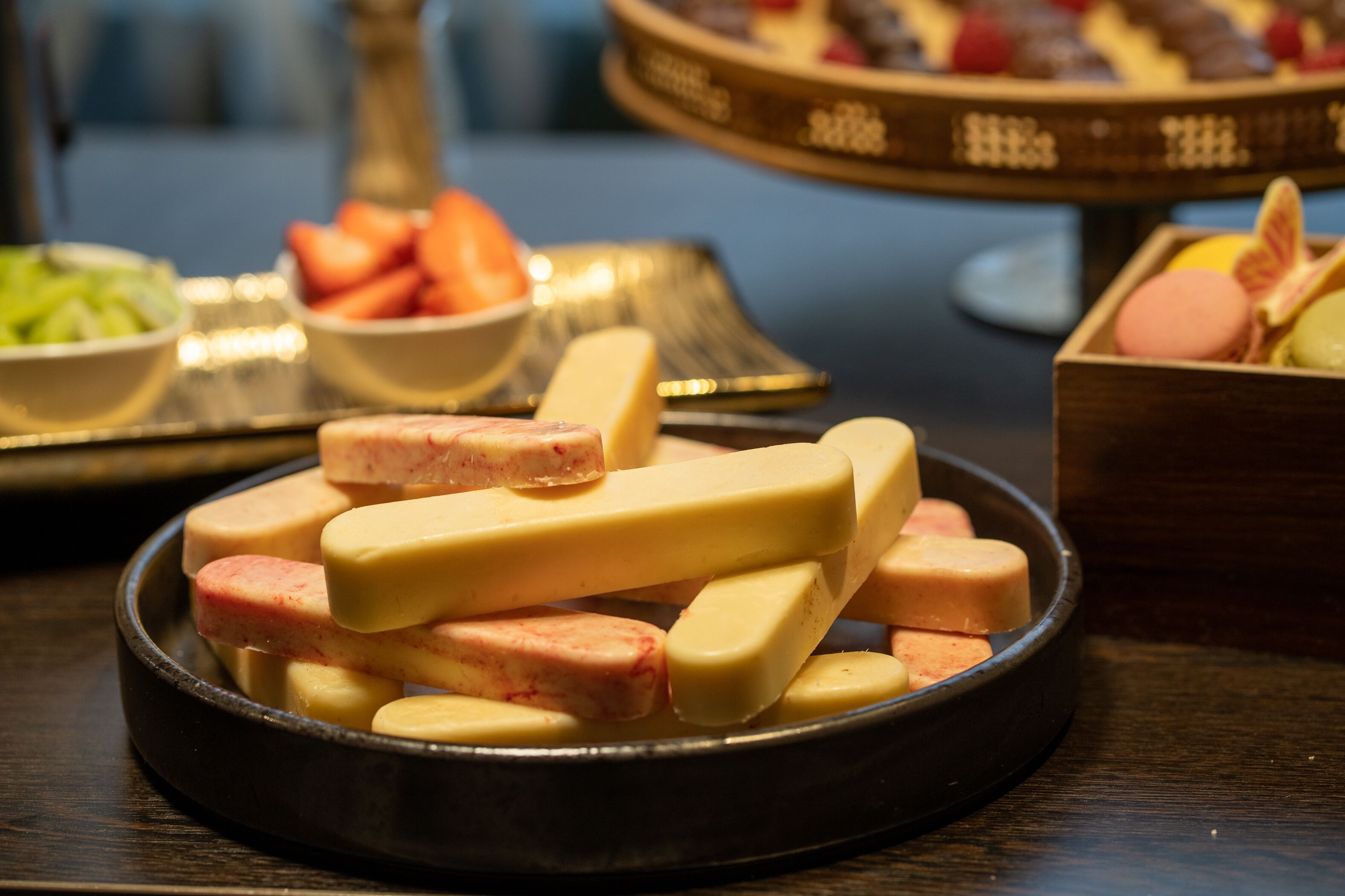 A variety of food items including sausages and cheese in a black bowl.