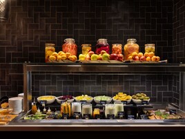 Un bufé de desayuno con frutas, verduras y bebidas variadas.
