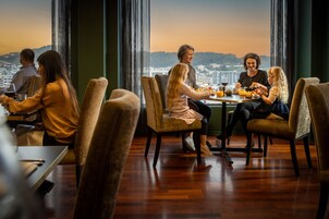 A group of people dining at a table with a city view.