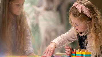 Two children playing with colorful wooden blocks on a table.