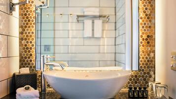 Un baño moderno con un lavabo de diseño, un espejo y un revestimiento mural con patrón de panal.