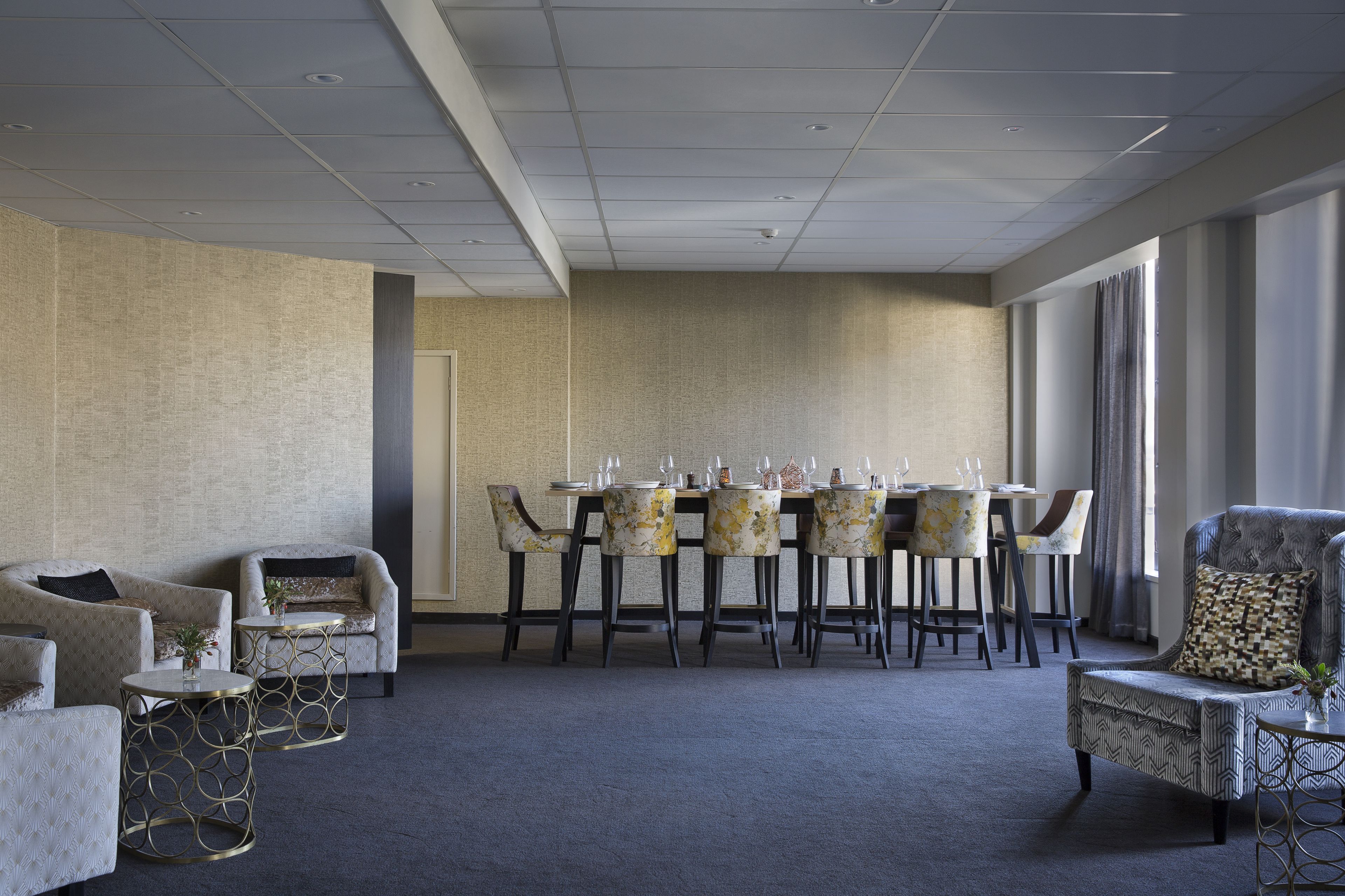 A conference room with a round table, chairs, and a sofa.