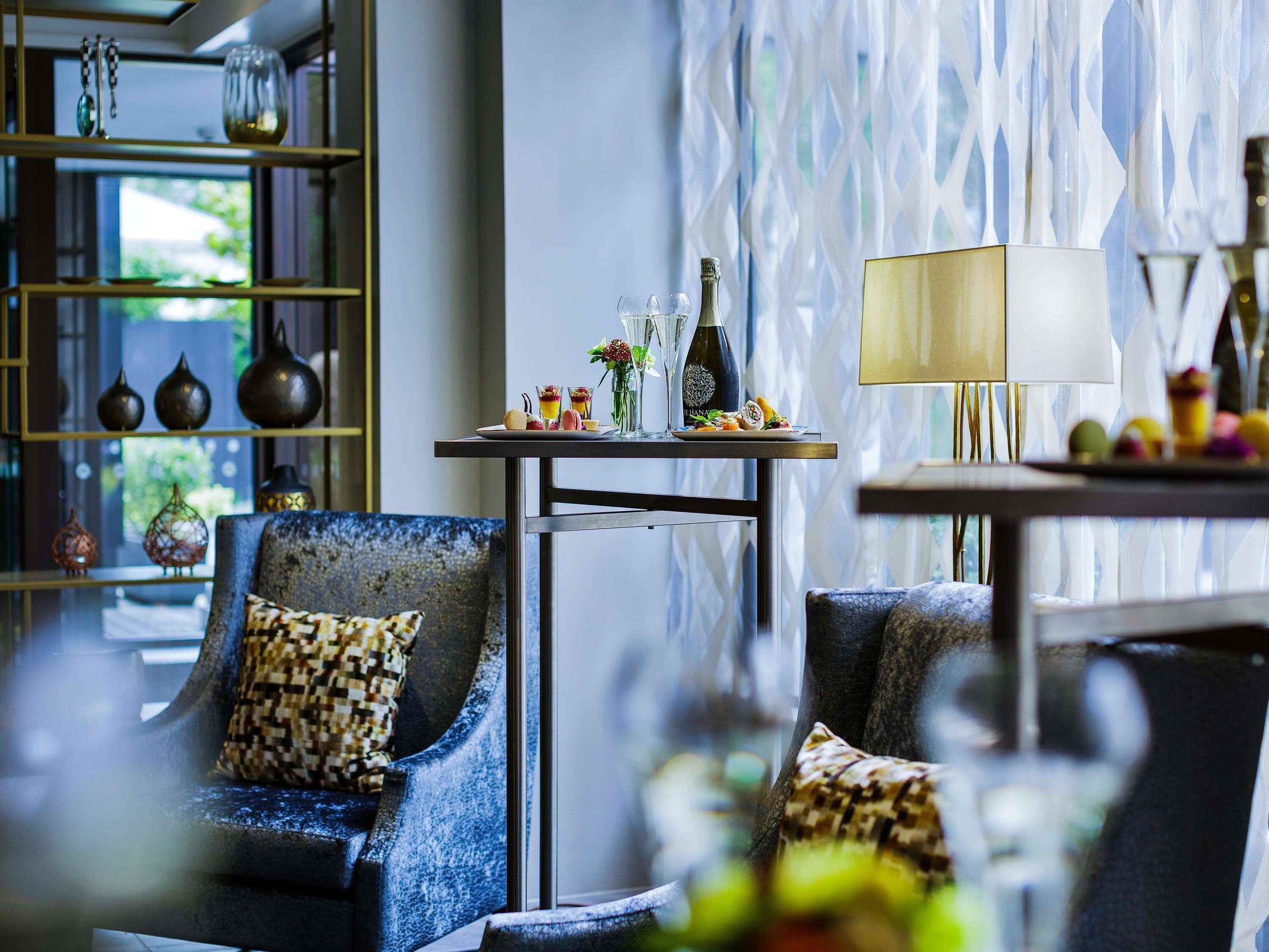 A modern lounge area with a sofa, a small table with drinks, and decorative items.