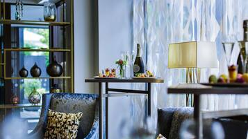 A modern lounge area with a sofa, a small table with drinks, and decorative items.