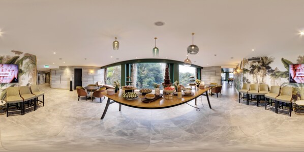 A spacious, well-lit reception area with a curved reception desk, comfortable seating, and a large window offering a view of the outdoors. - Mövenpick Hotel Wellington (Wellington)