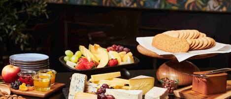 A cheese board with various cheeses, fruits, and nuts.