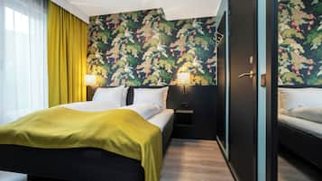 Habitación de hotel con cama, mesitas de noche, una puerta y una ventana con cortinas.