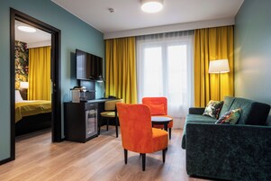 Una habitación de hotel con cama, escritorio, sofá y televisor.