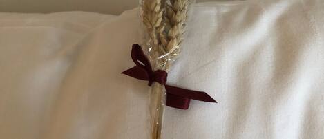 A bouquet of dried wheat stalks in a clear vase with a red ribbon.