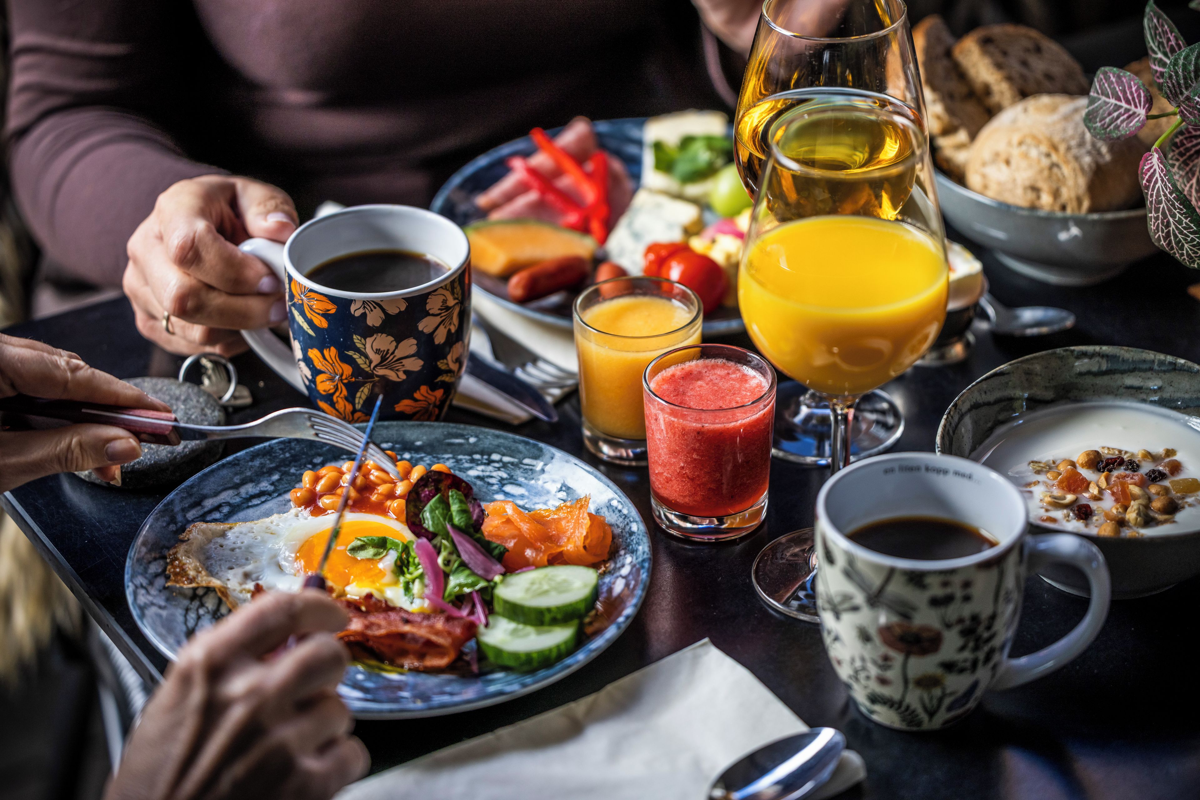 Disposição de alimentos e bebidas em uma mesa para o café da manhã.