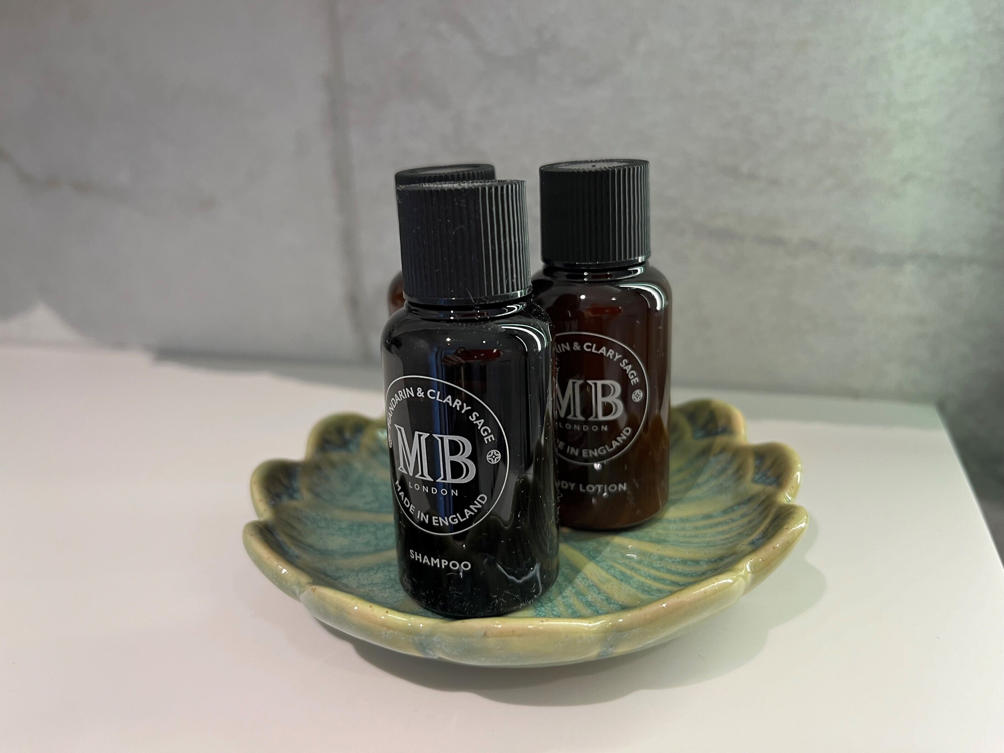 Two bottles of hair care products on a ceramic dish.
