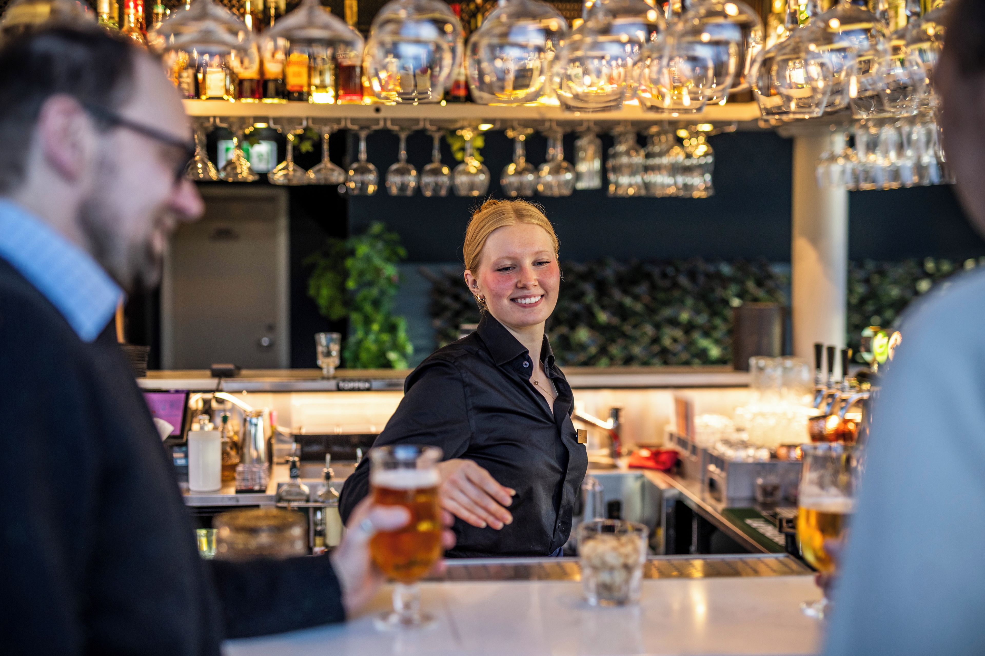 Un espace bar avec un barman et des clients.