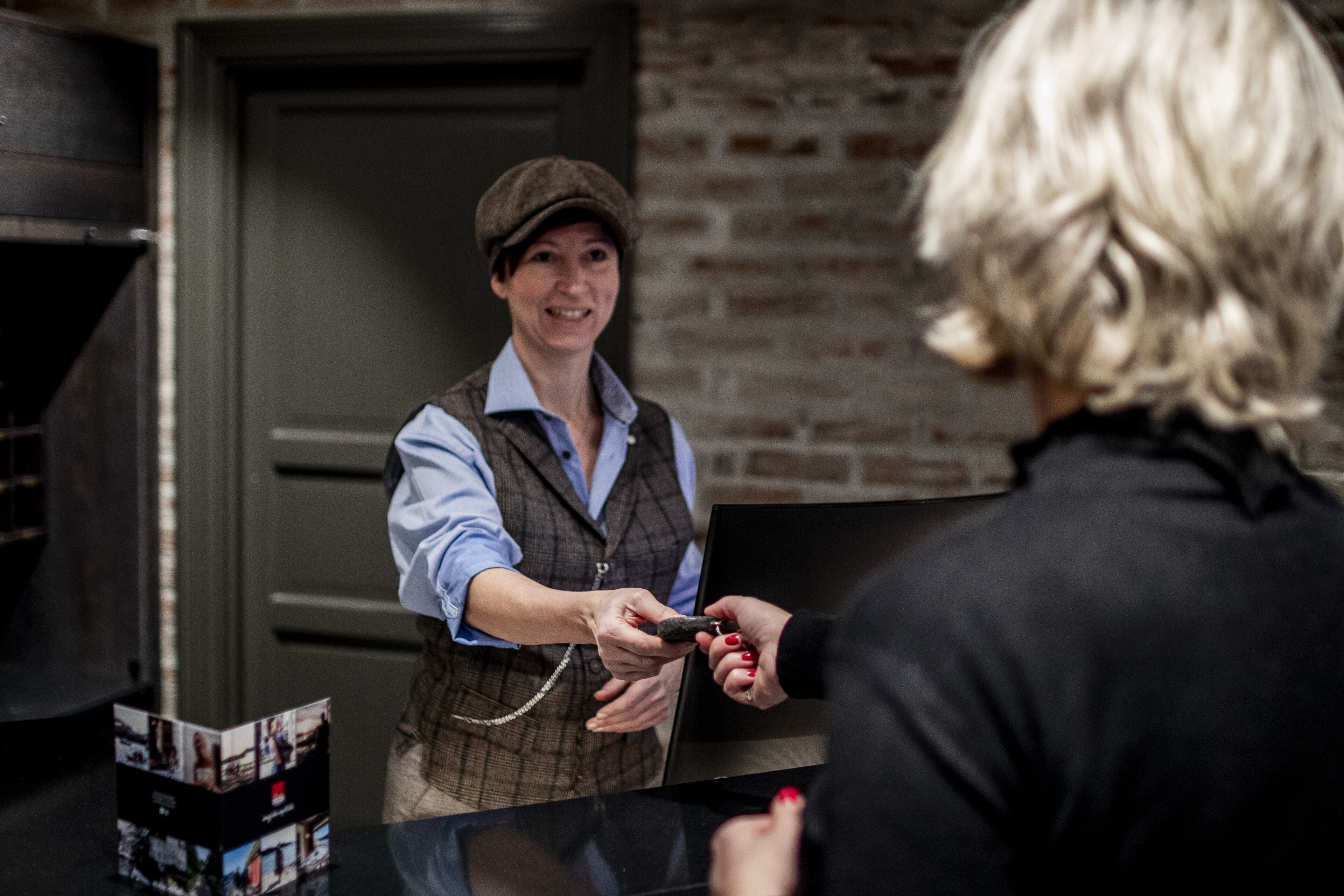 A person handing over a black object to another person.