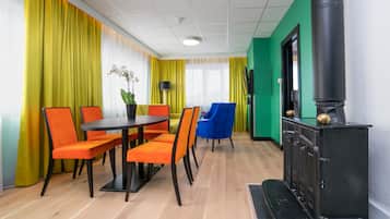 Quarto moderno com área de jantar, fogão preto e cortinas amarelas vibrantes.