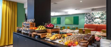 A buffet with various fruits, vegetables, and beverages.
