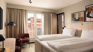 A hotel room with a bed, a desk, a chair, and a window with curtains. - Scandic Victoria (Oslo)