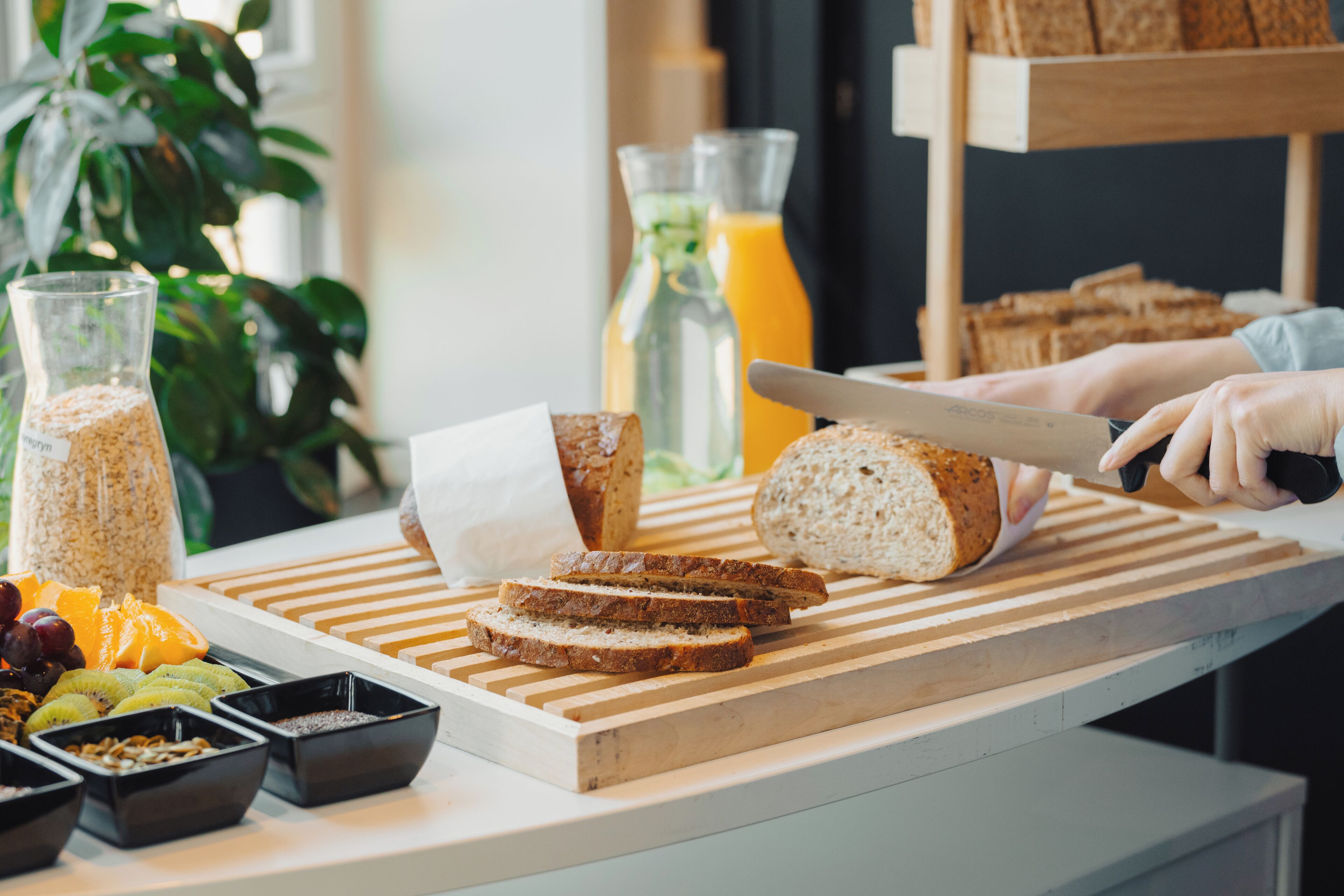 A kitchen counter with sliced bread, a knife, and various food items.