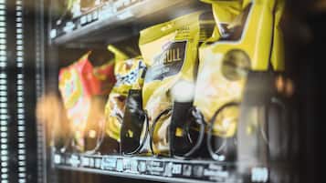 Máquina de vendas com diversos petiscos, incluindo pacotes de batatas e outros alimentos embalados.