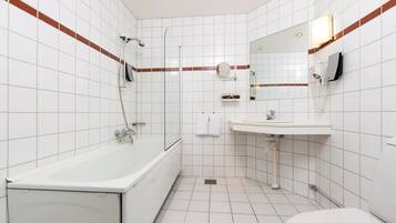 Un baño con una bañera, un lavabo y un espejo.