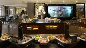A buffet area with various food stations, a large aquarium, and a seating area with tables and chairs. - Four Points by Sheraton Lahore (Lahore)
