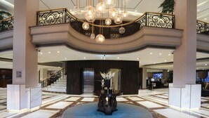 A grand lobby with a marble floor, a central round table with a vase of flowers, and a staircase leading to an upper level. - Four Points by Sheraton Lahore (Lahore)