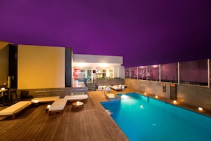 Una piscina al aire libre, sillones reclinables de piscina