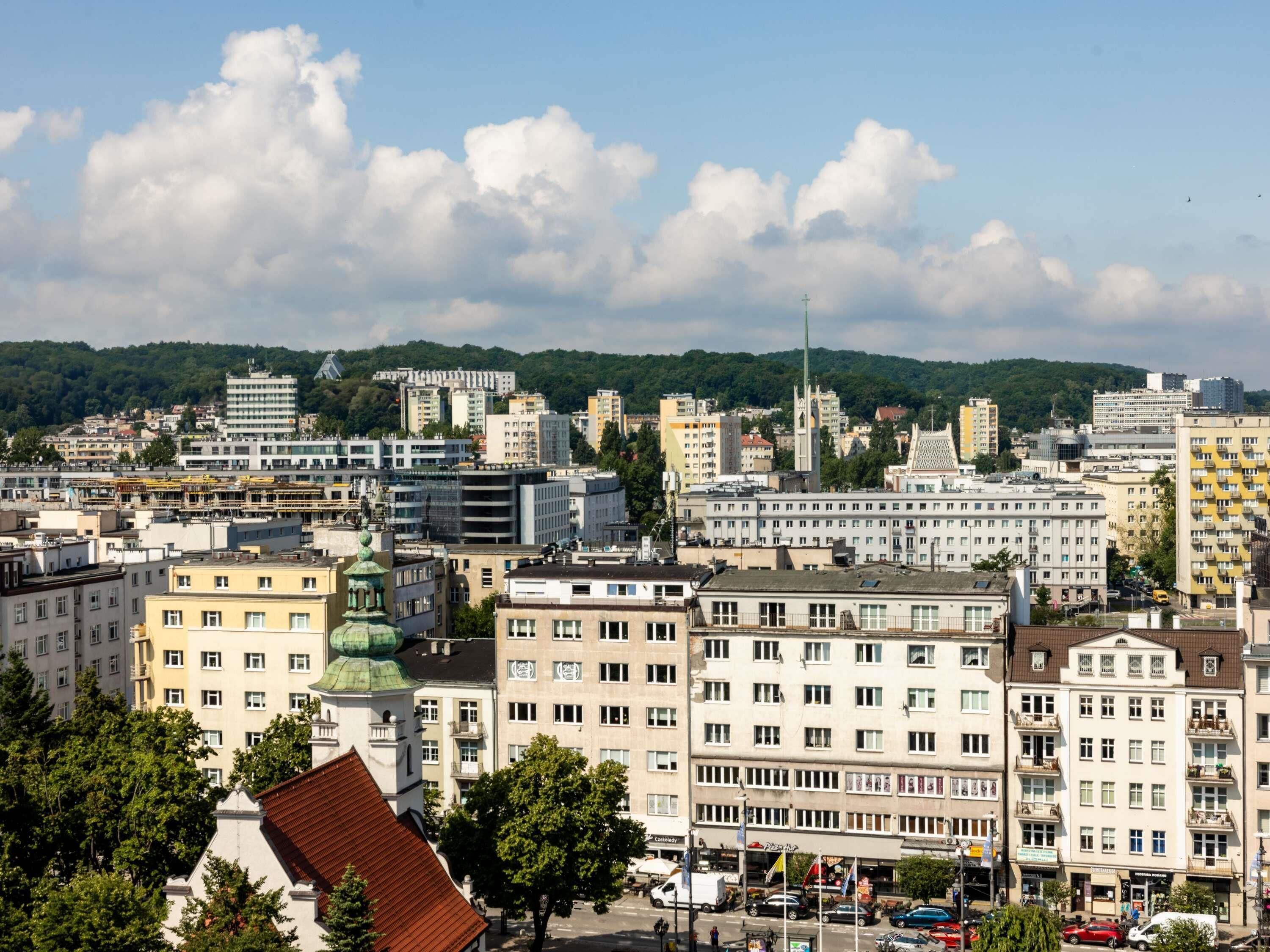 A cityscape with a variety of buildings, including a prominent church with a tall spire.