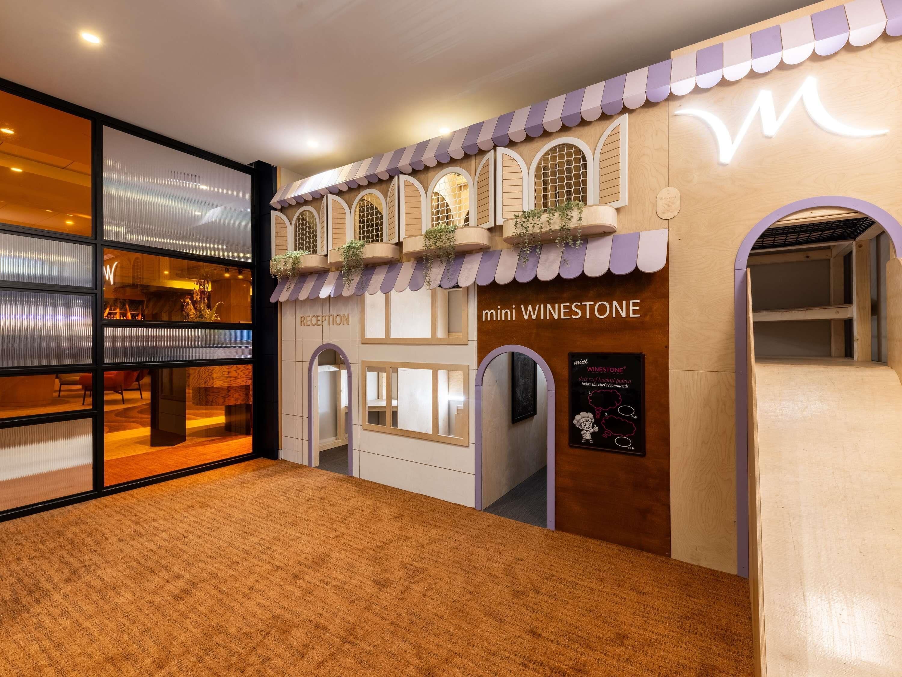 A reception area with a wooden facade, a reception desk, and a sign for 'mini WINESTONE.'