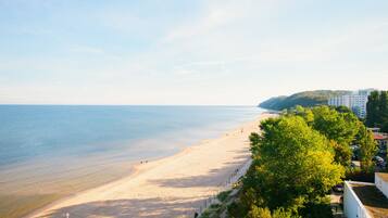 Di pantai, payung pantai, dan handuk pantai