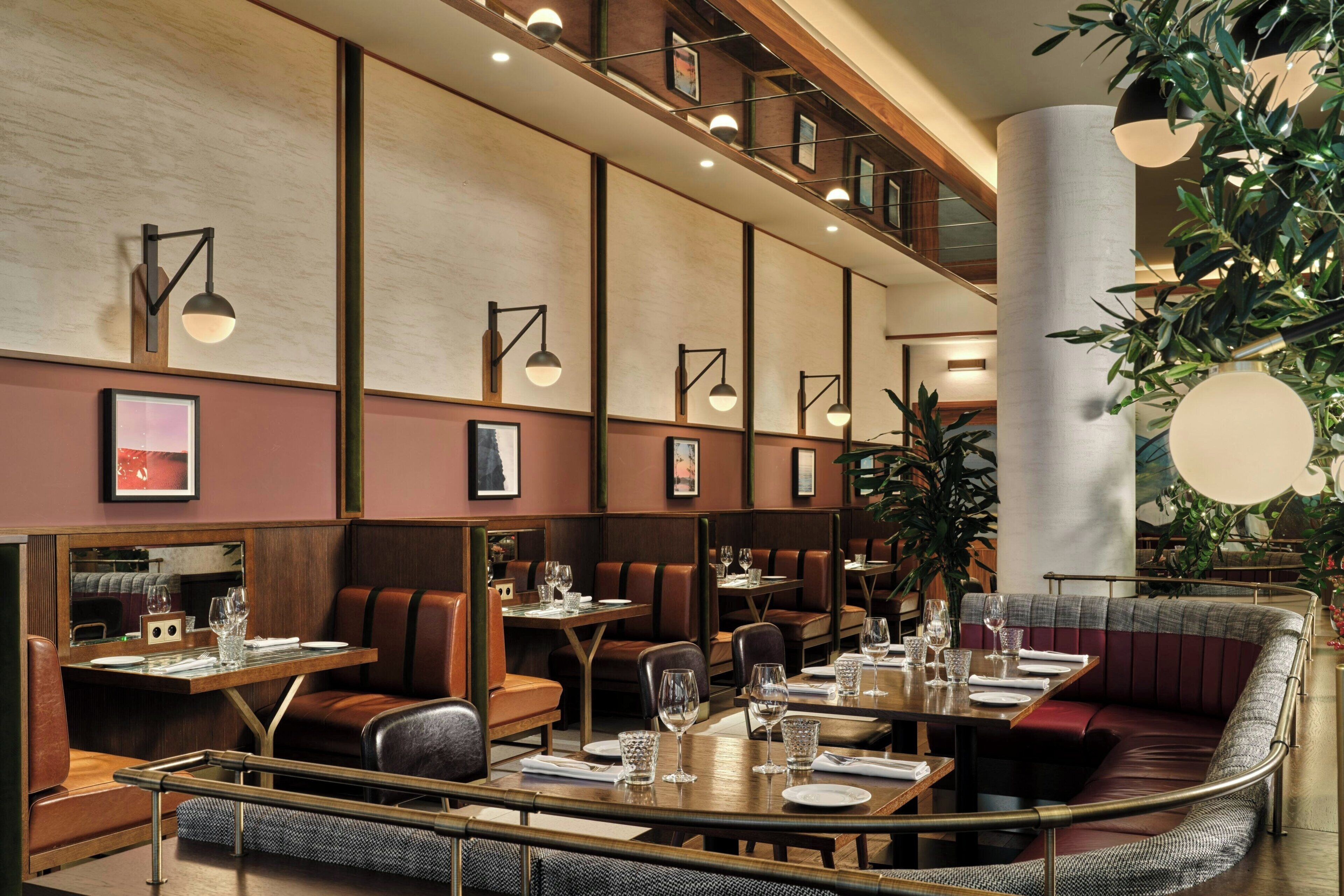 Un restaurante con mesasychairs, pisos de madera e iluminación moderna.