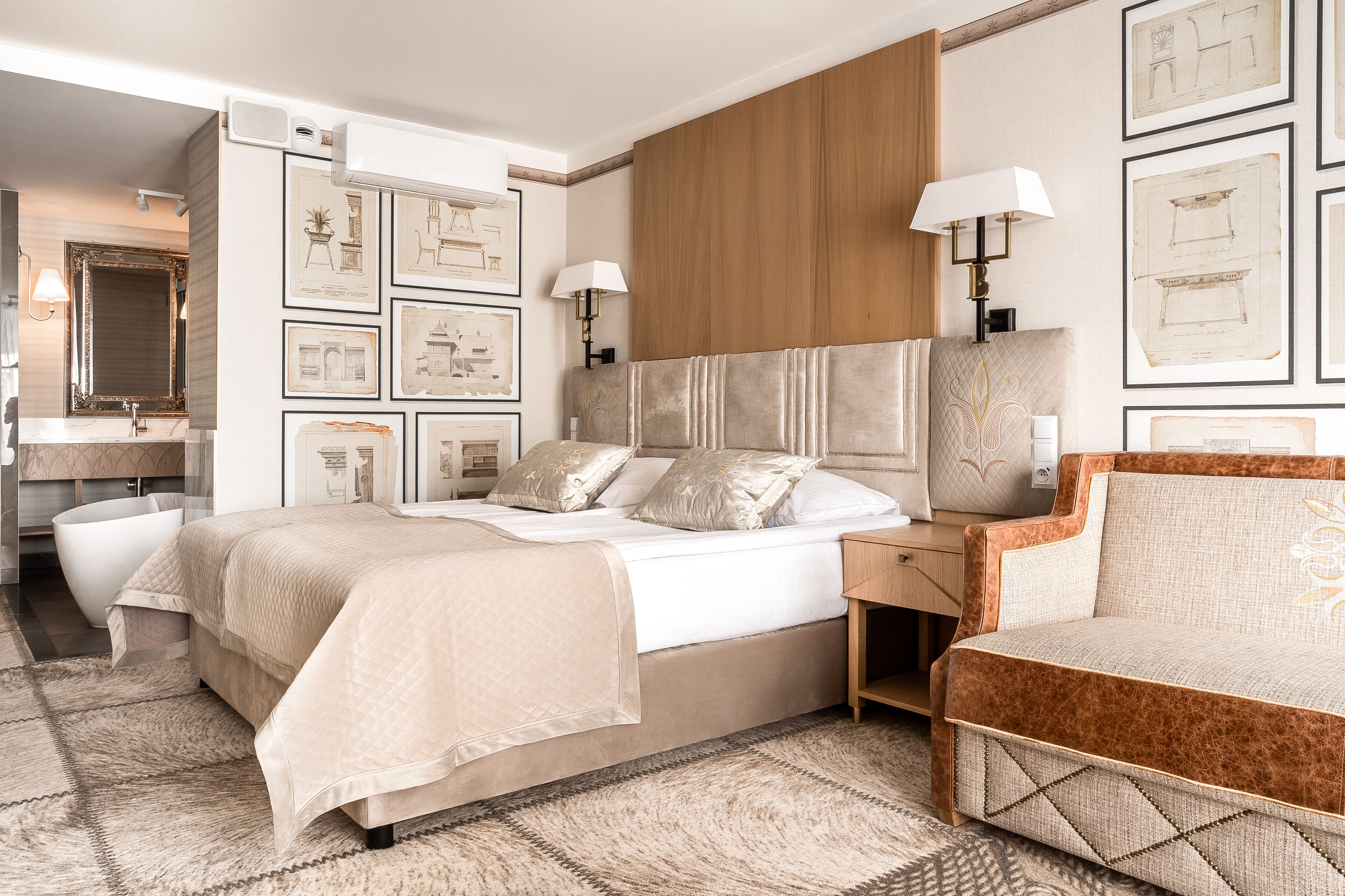 A modern bedroom with a large bed, a sofa, and a vanity with a mirror.
