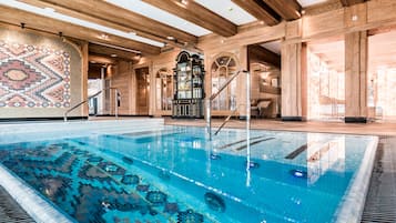 Una piscina cubierta, una piscina al aire libre, tumbonas