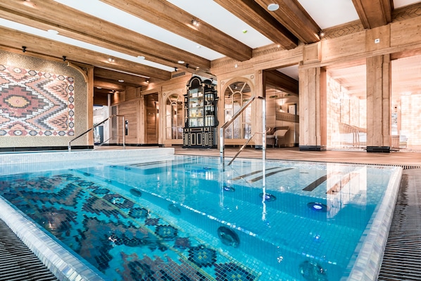 A swimming pool with a mosaic tile design, wooden beams, and a staircase leading to an upper level. - Bachleda Hotel Kasprowy**** (Zakopane)