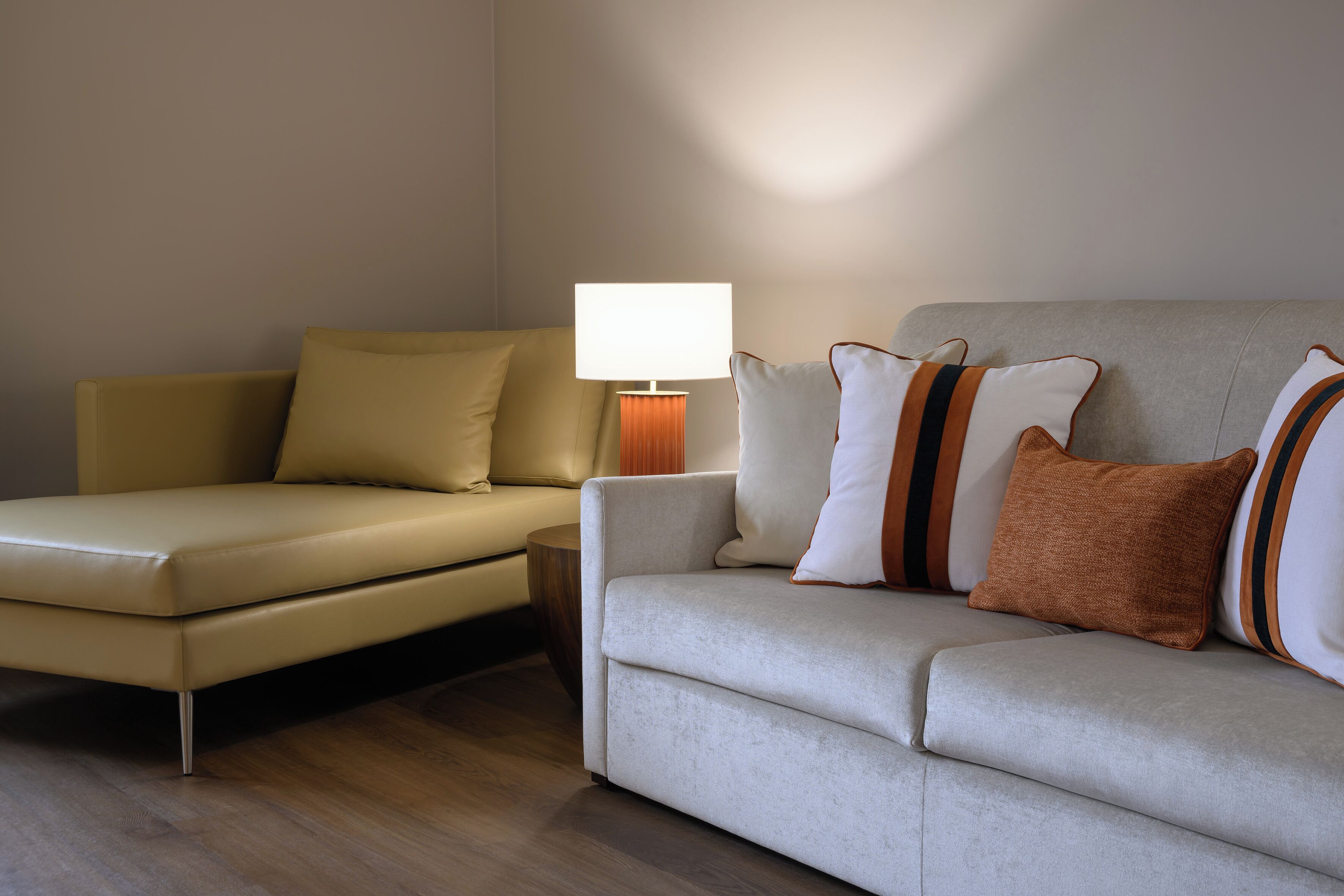 A modern living room with two sofas, a side table, and a lamp.