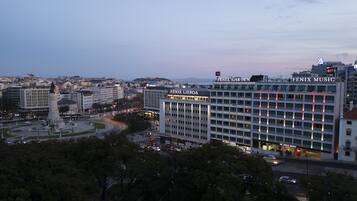 Un hotel de varios pisos, una entrada destacada y vistas de la ciudad circundante.