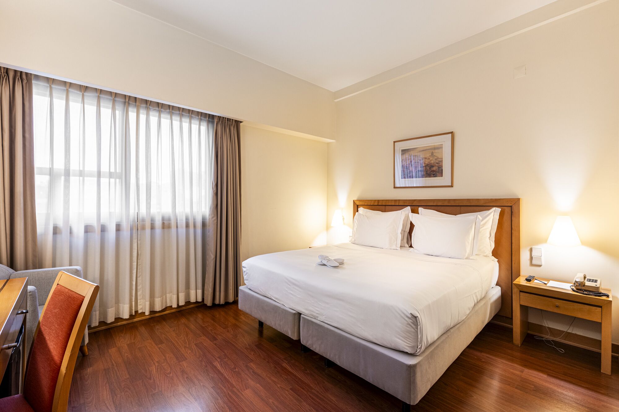 Una habitación de hotel con cama, escritorio y silla.