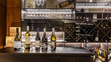 Zona de bar con botellas de vino y copas.