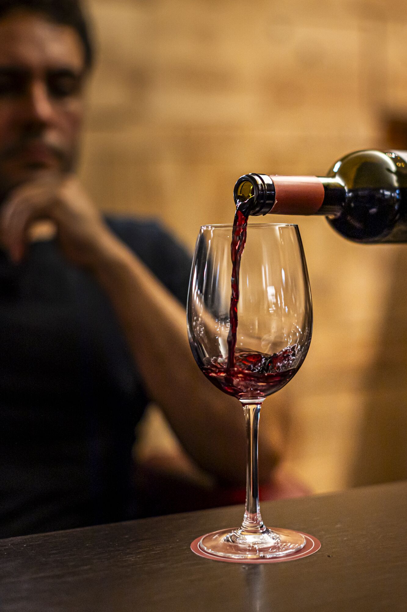 Un verre à vin est rempli de vin rouge sur une table.