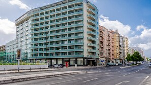 A multi-story hotel with a modern design, featuring balconies on each floor and a prominent entrance.