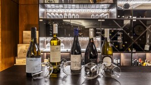 Zona de degustación de vinos con botellas y copas sobre una mesa de madera.