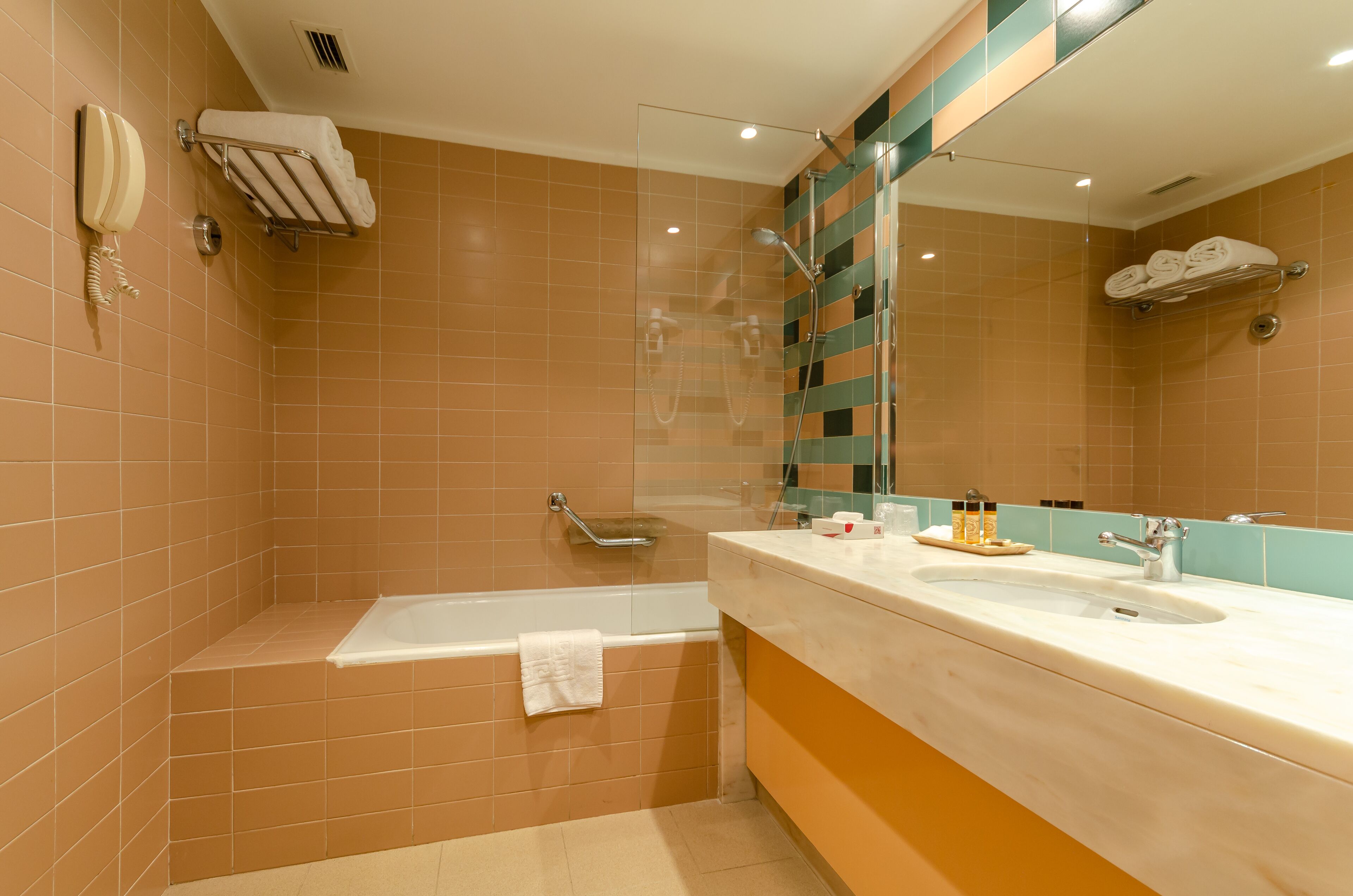 Une salle de bain avec une baignoire, un lavabo et un miroir.