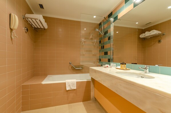A bathroom with a bathtub, a sink, and a mirror.