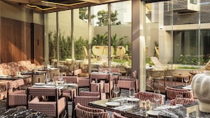 A restaurant with tables and chairs, a large window, and a view of the outdoors. - EVOLUTION Valbom (Lisbon)