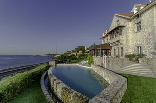 Una piscina al aire libre, sillones reclinables de piscina