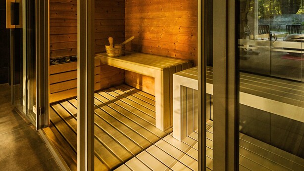 A modern interior with wooden walls and a glass partition.