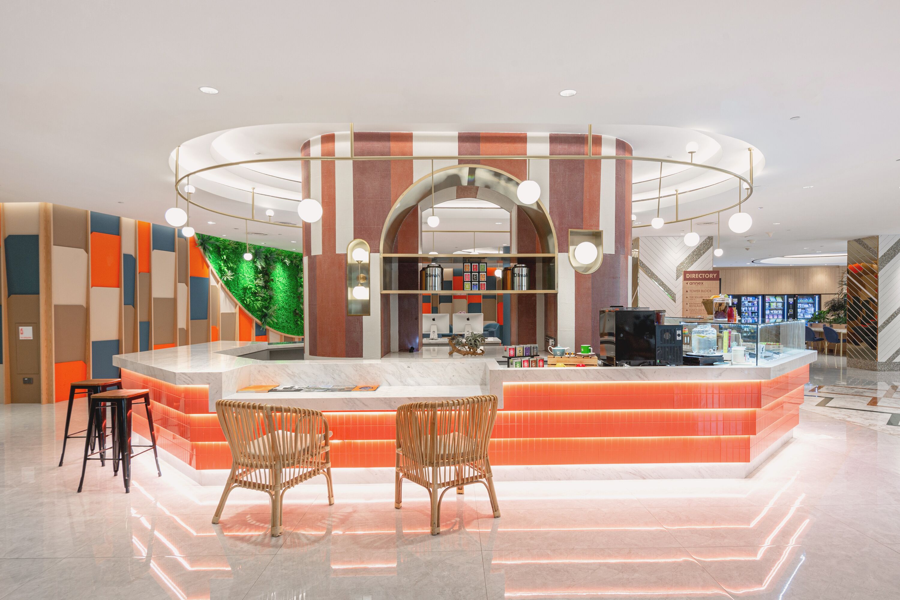 A modern lobby with a central island, seating area, and a directory sign.