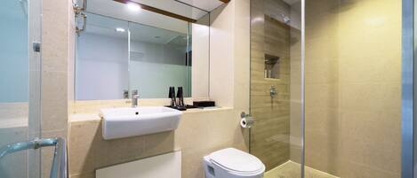 A modern bathroom with a glass shower enclosure, a white sink, and a toilet.
