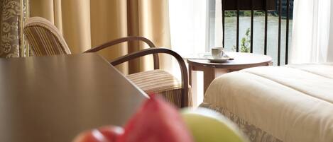 Habitación de hotel con una mesa de comedor, una cama y vistas a un puente.